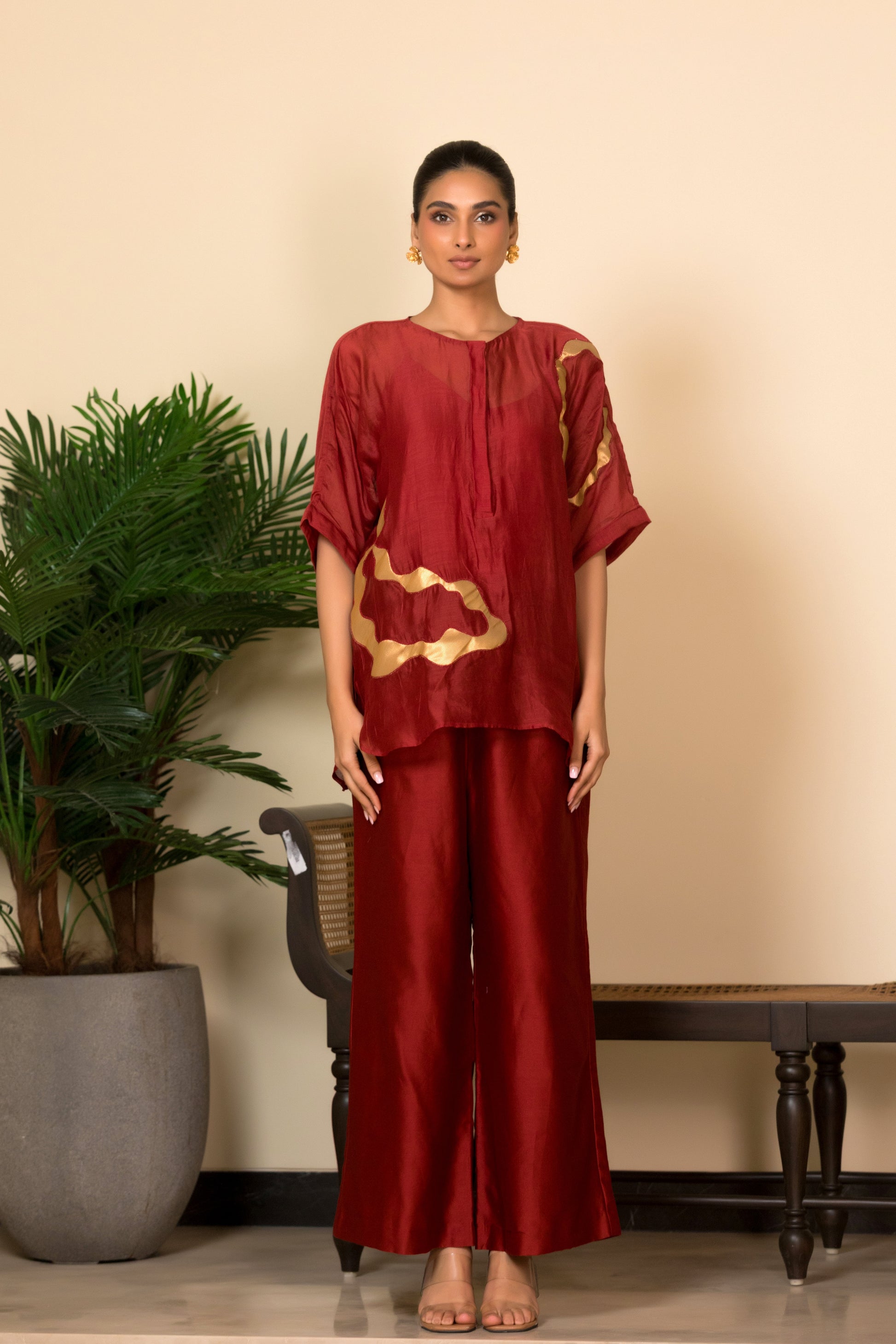 Red Banarasi chanderi silk shirt with asymmetrical handcrafted patch detailing for women, Indian luxury designer wear paired with matching silk pants.