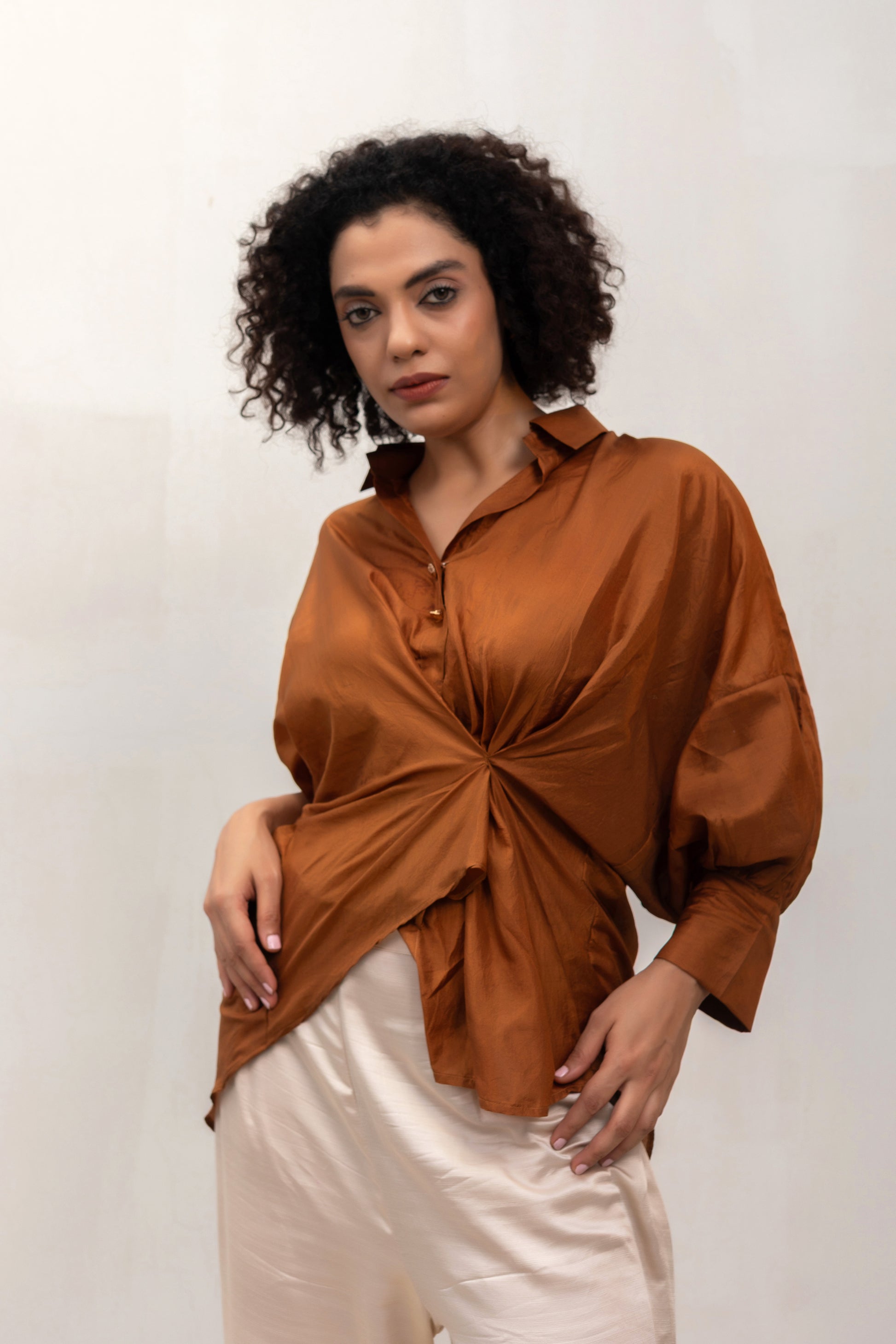 Model in a camel Twist drape shirt with straight trousers — Eeda