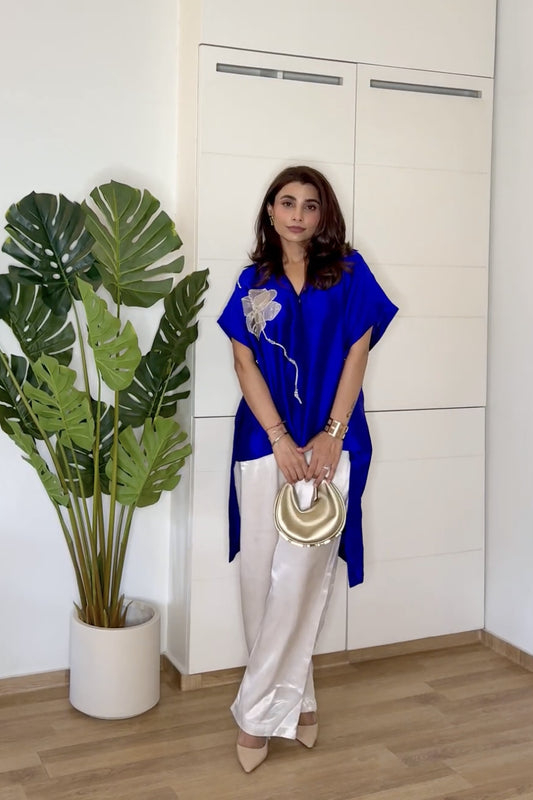Ishita Saluja wearing the Eeda Varq Bloom Shirt in electric blue silk with a metallic bloom appliqué, styled with ivory satin trousers