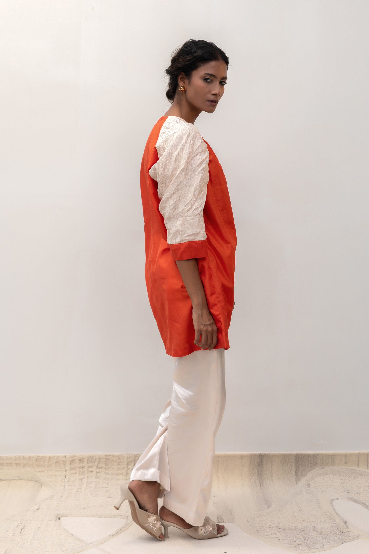 Model in an orange Varq Duet tunic styled with pants — Eeda Varq