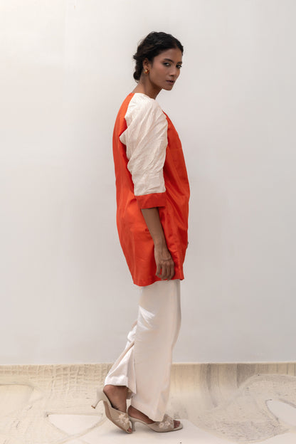 Model in an orange Varq Duet tunic styled with pants — Eeda Varq