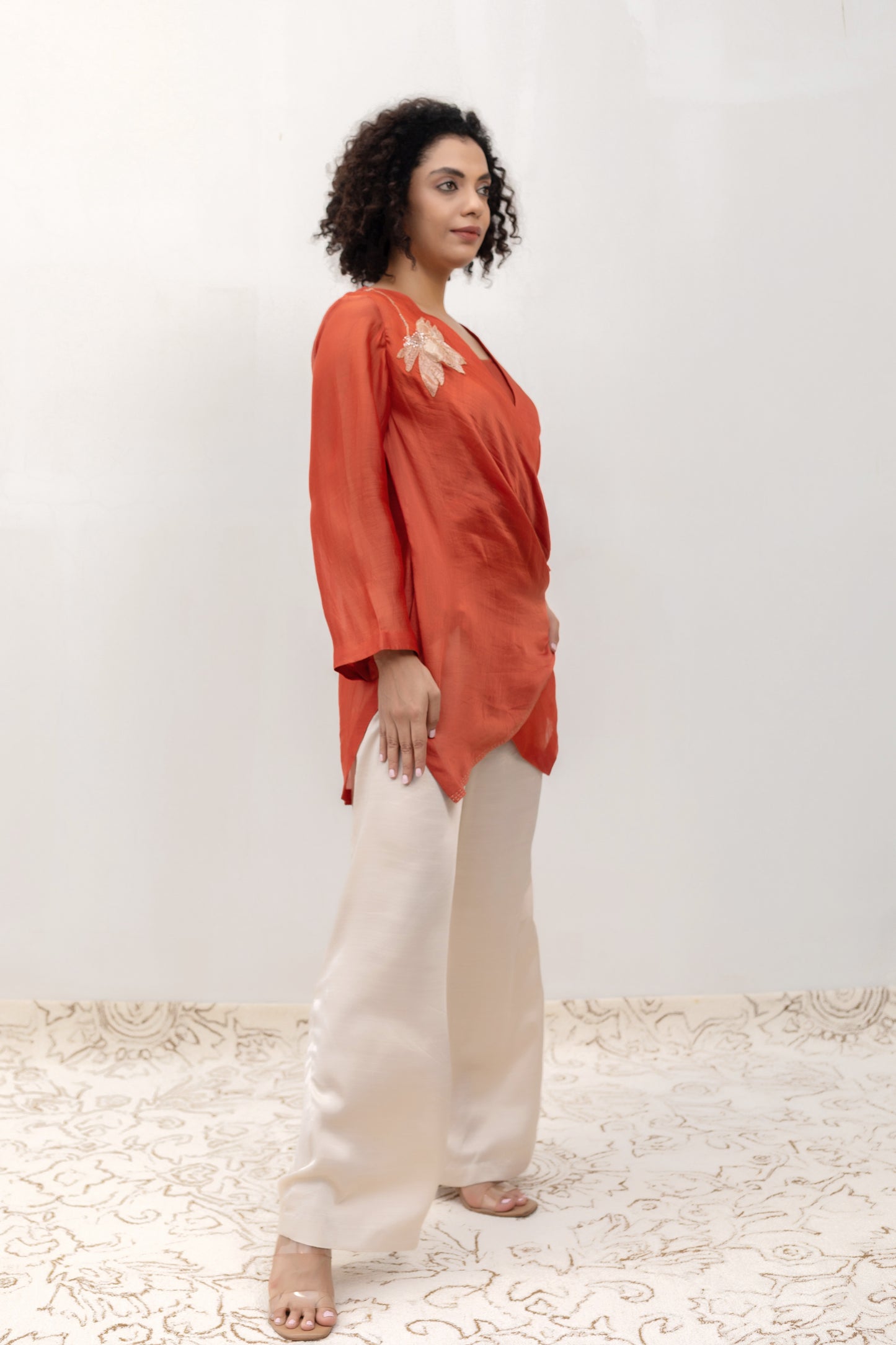 Model in a rust Varq Petals drape top styled with pants — Eeda