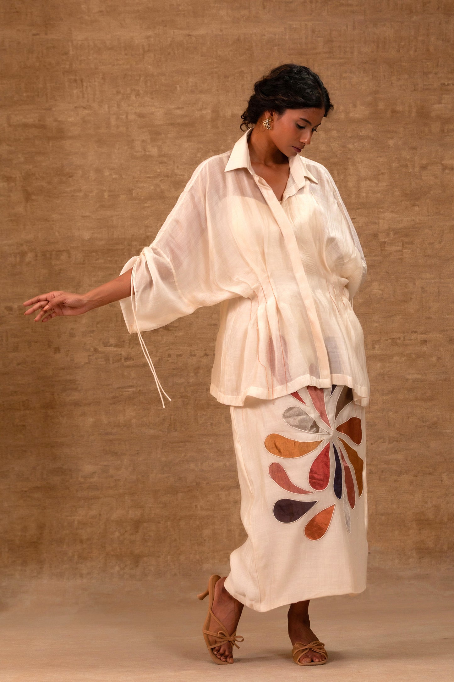 Model in a ivory silk chanderi pleated shirt with a patch skirt and bustier — Eeda
