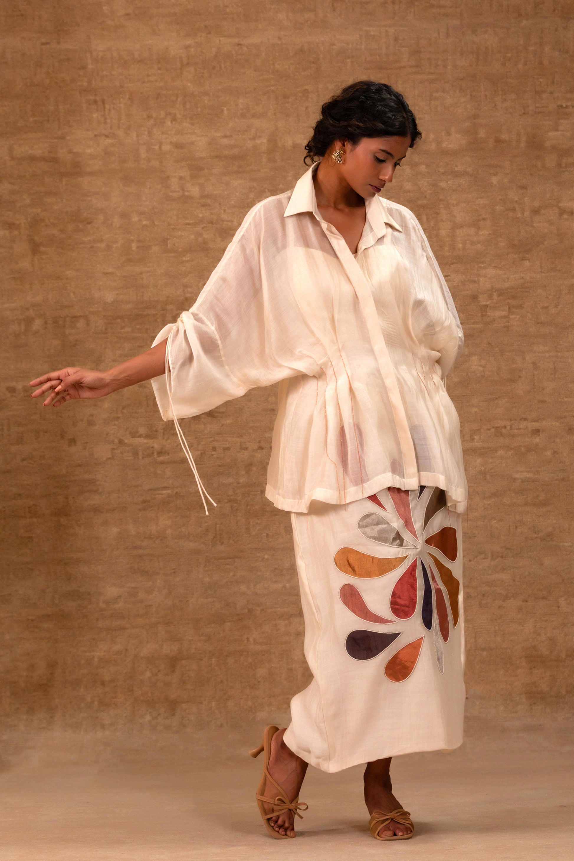 Model in a ivory silk chanderi pleated shirt with a patch skirt and bustier — Eeda