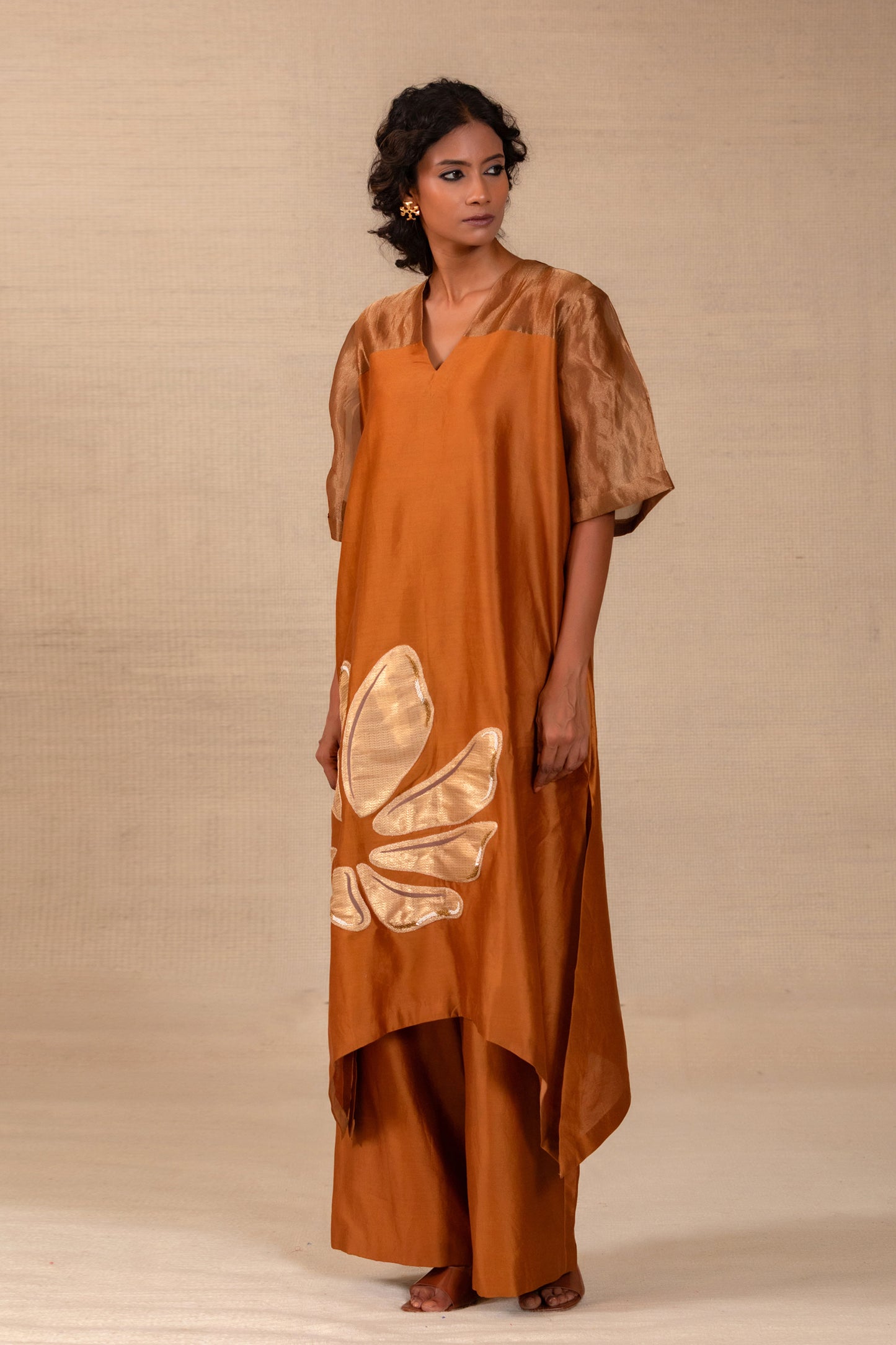 Model in a dark amber long kurta set with tissue yoke and matching pants — Eeda Gulnaar