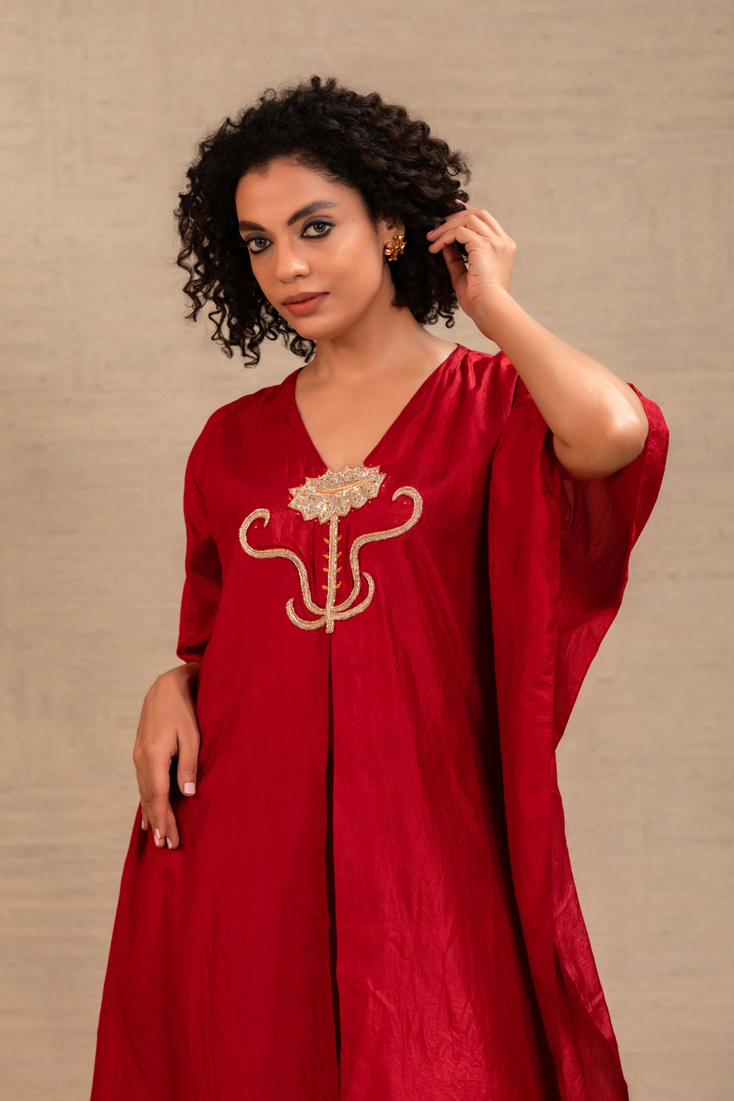 Woman in a red silk kurta set with a flower motif at the neck and straight pants — Eeda Silsila