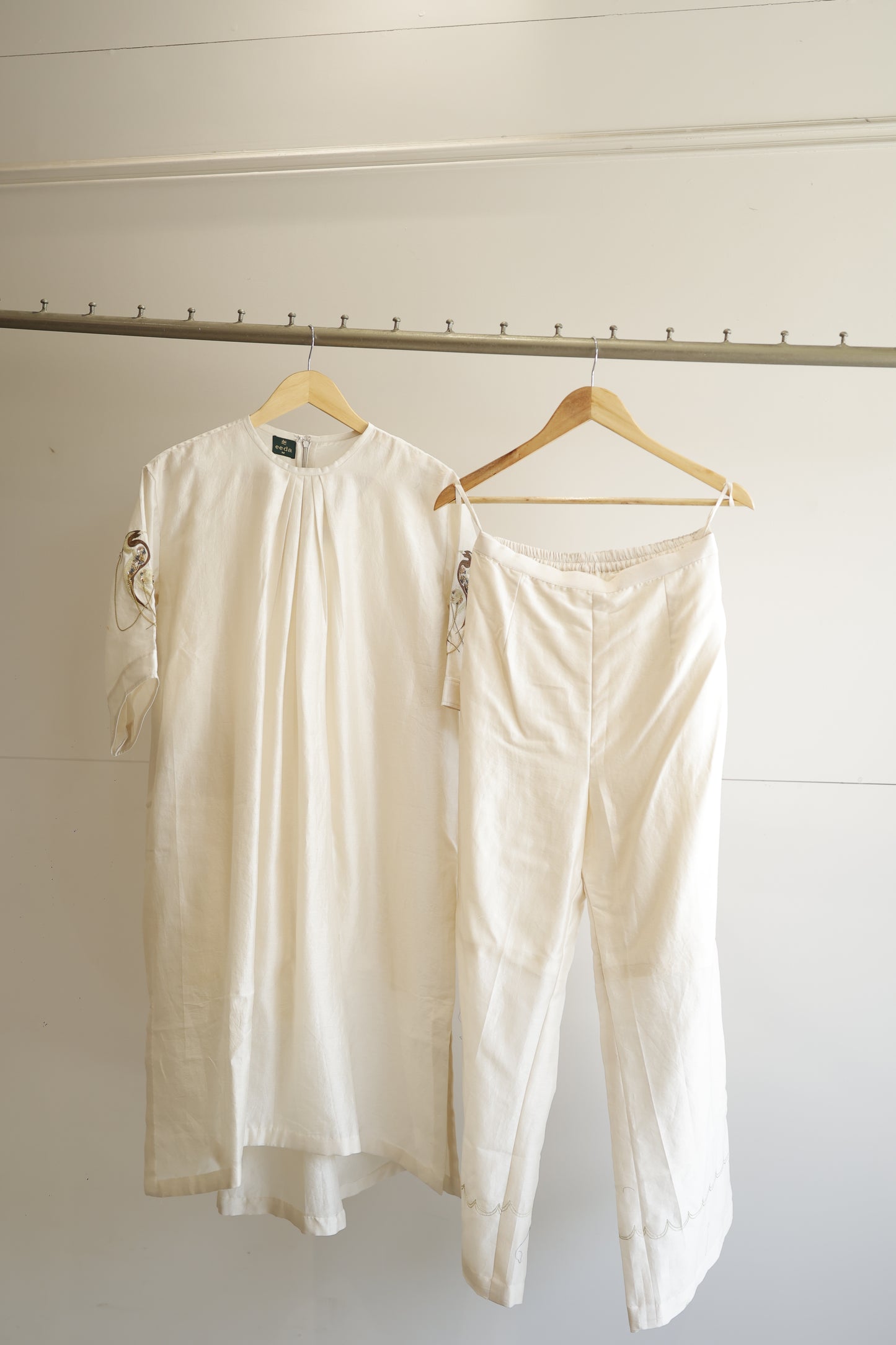 eeda Tinka — chanderi gathered kurta with hand-embroidered sleeve and chain detail, paired with white straight trousers, handcrafted in Varanasi
