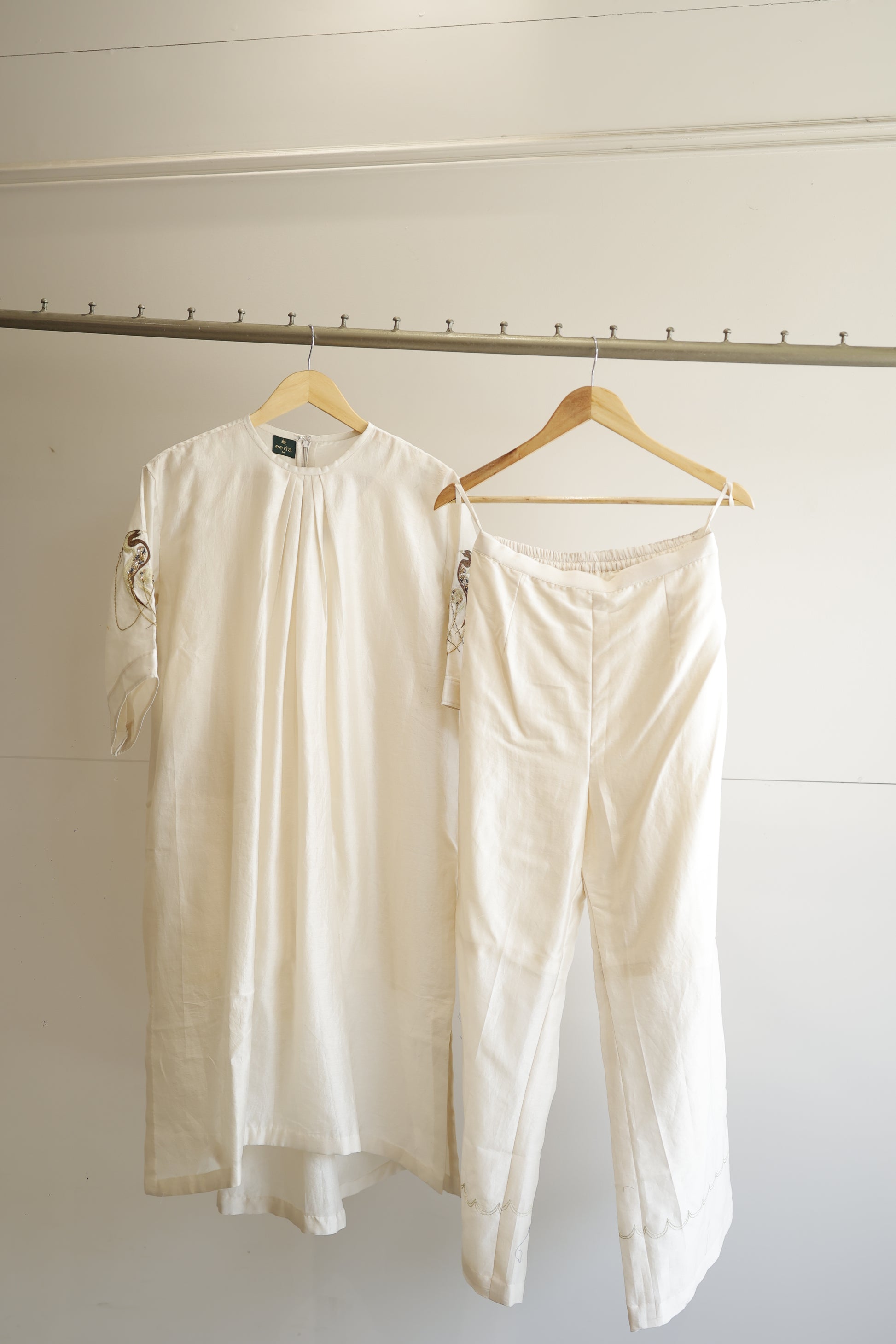 eeda Tinka — chanderi gathered kurta with hand-embroidered sleeve and chain detail, paired with white straight trousers, handcrafted in Varanasi
